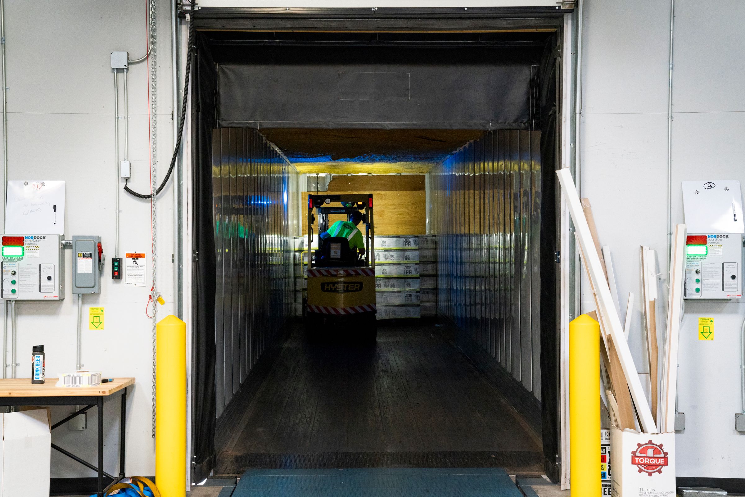 Forklift unloading palletized goods inside a loading dock